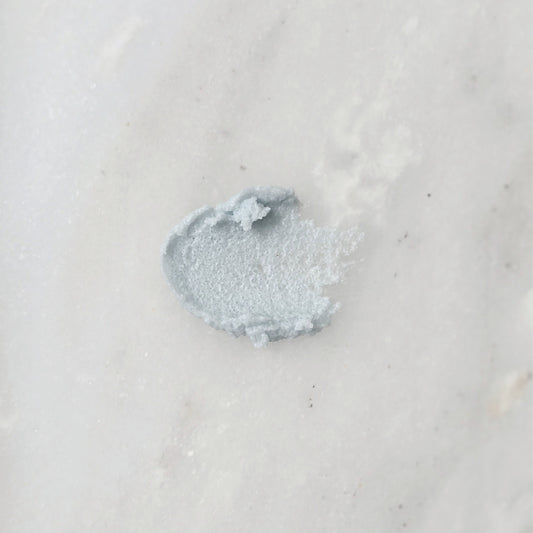 Smear of a blue sugar scrub on a marble background