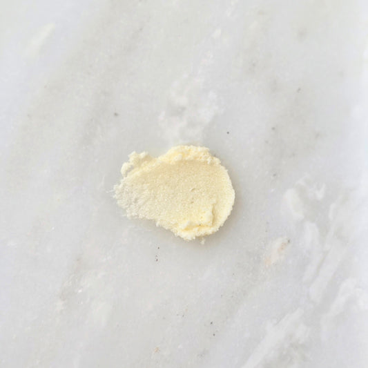 Smear of a yellow sugar scrub on a marble background