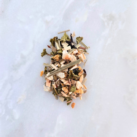 Heap of dried herbs and leaves on a light marble surface