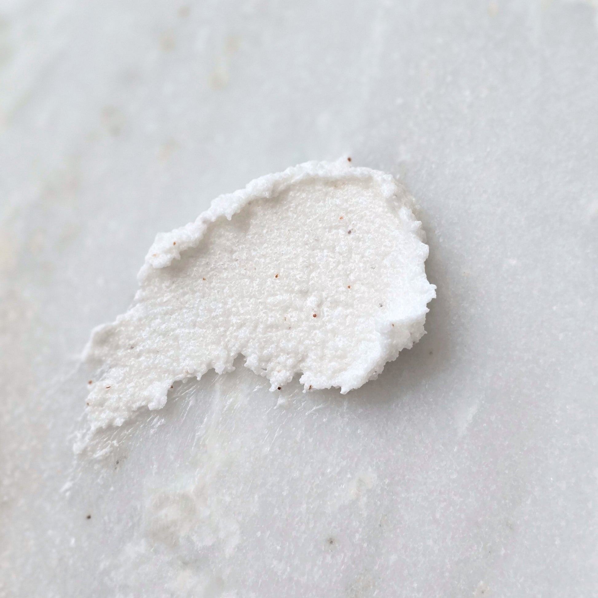 Smear of a sugar scrub with apricot seed on a marble surface