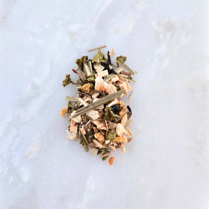 Heap of dried herbs and leaves on a light marble surface