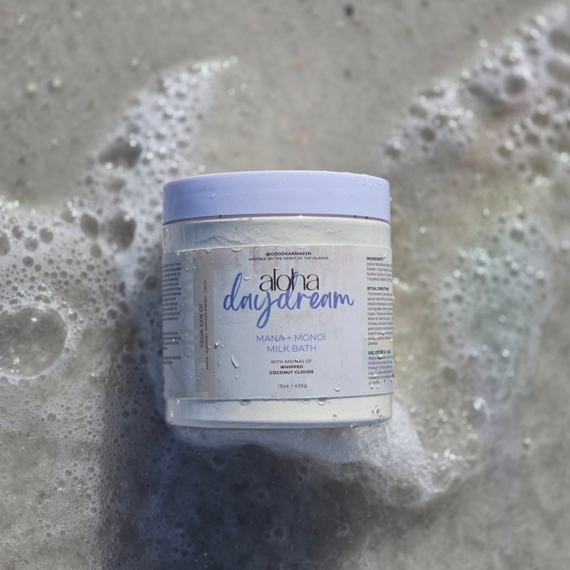Photo of Aloha Daydream coconut milk bath laying on the sand as water laps around it.