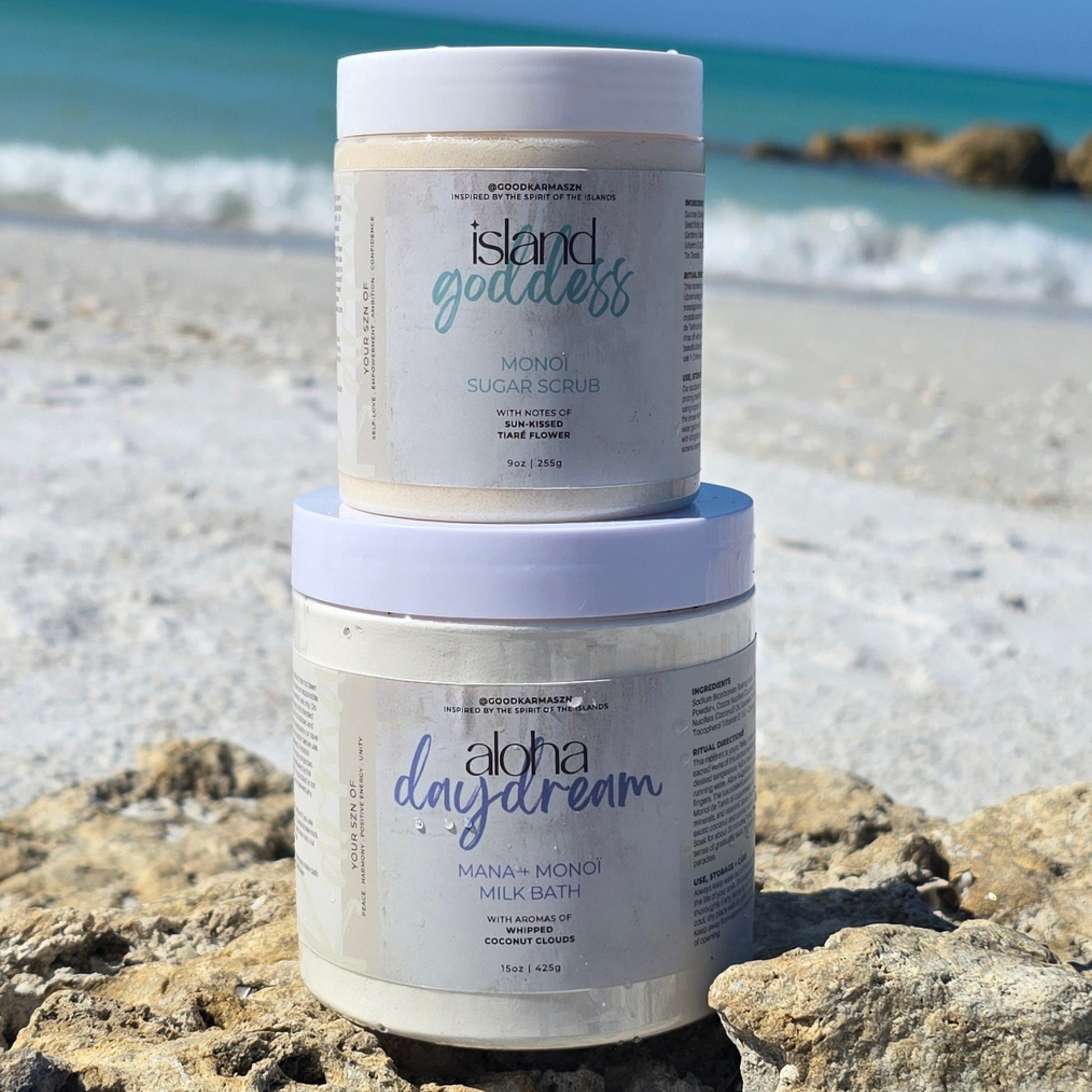 Two containers of Island Goddess and Aloha Daydream products on a beach.