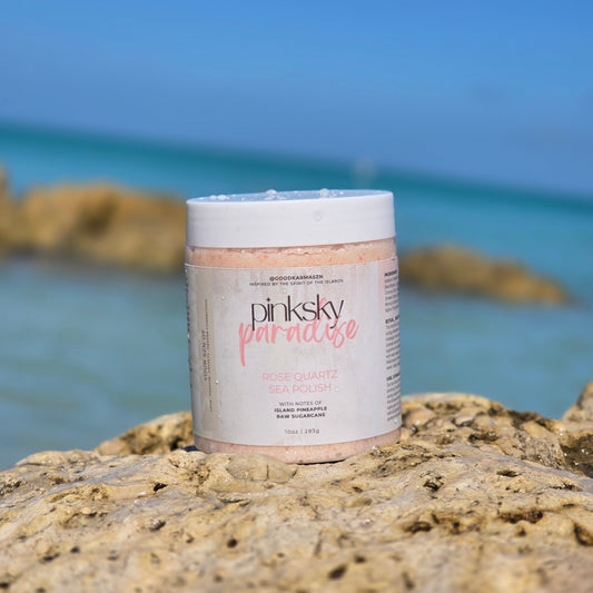 Jar of pinksky paradise pink sea salt scrub on a rock with ocean in the background