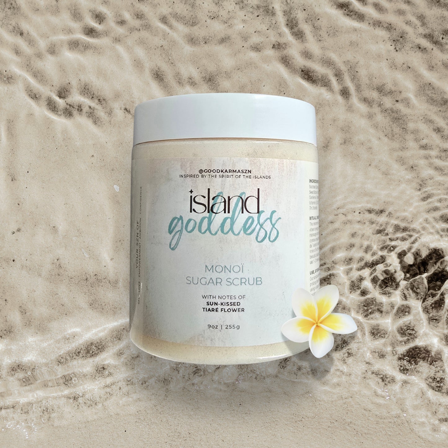 Jar of island goddess monoi sugar scrub on a textured beige background