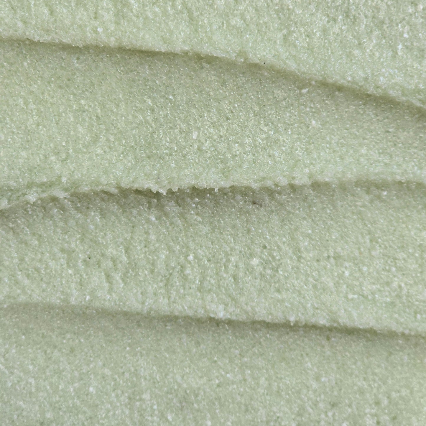 Close up of light green whipped sugar scrub texture 
