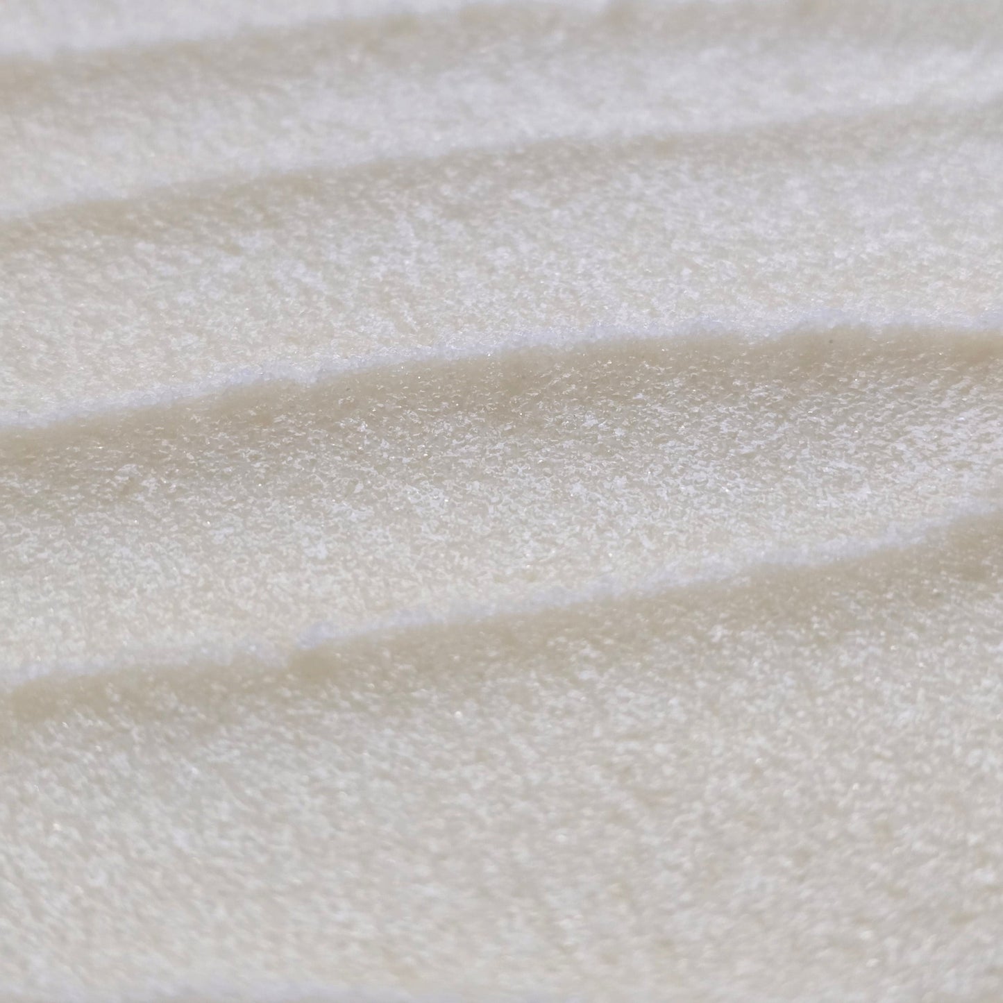 Close up of light cream colored whipped sugar scrub texture 
