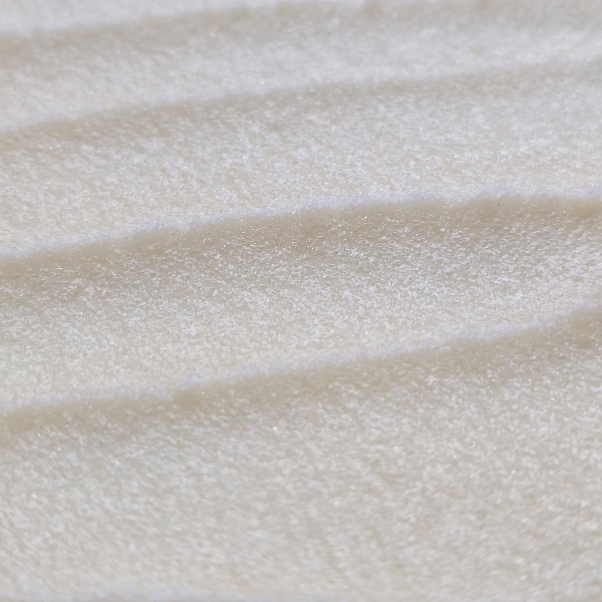 Close up of light cream colored whipped sugar scrub texture 