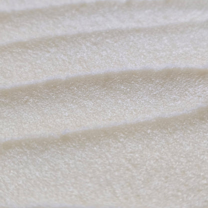 Close up of light cream colored whipped sugar scrub texture 